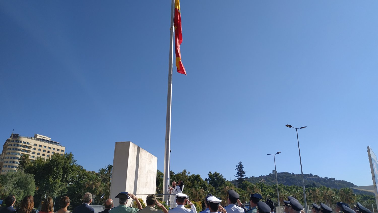 Representantes políticos y militares izan la nueva bandera española situada en el Puerto de Málaga