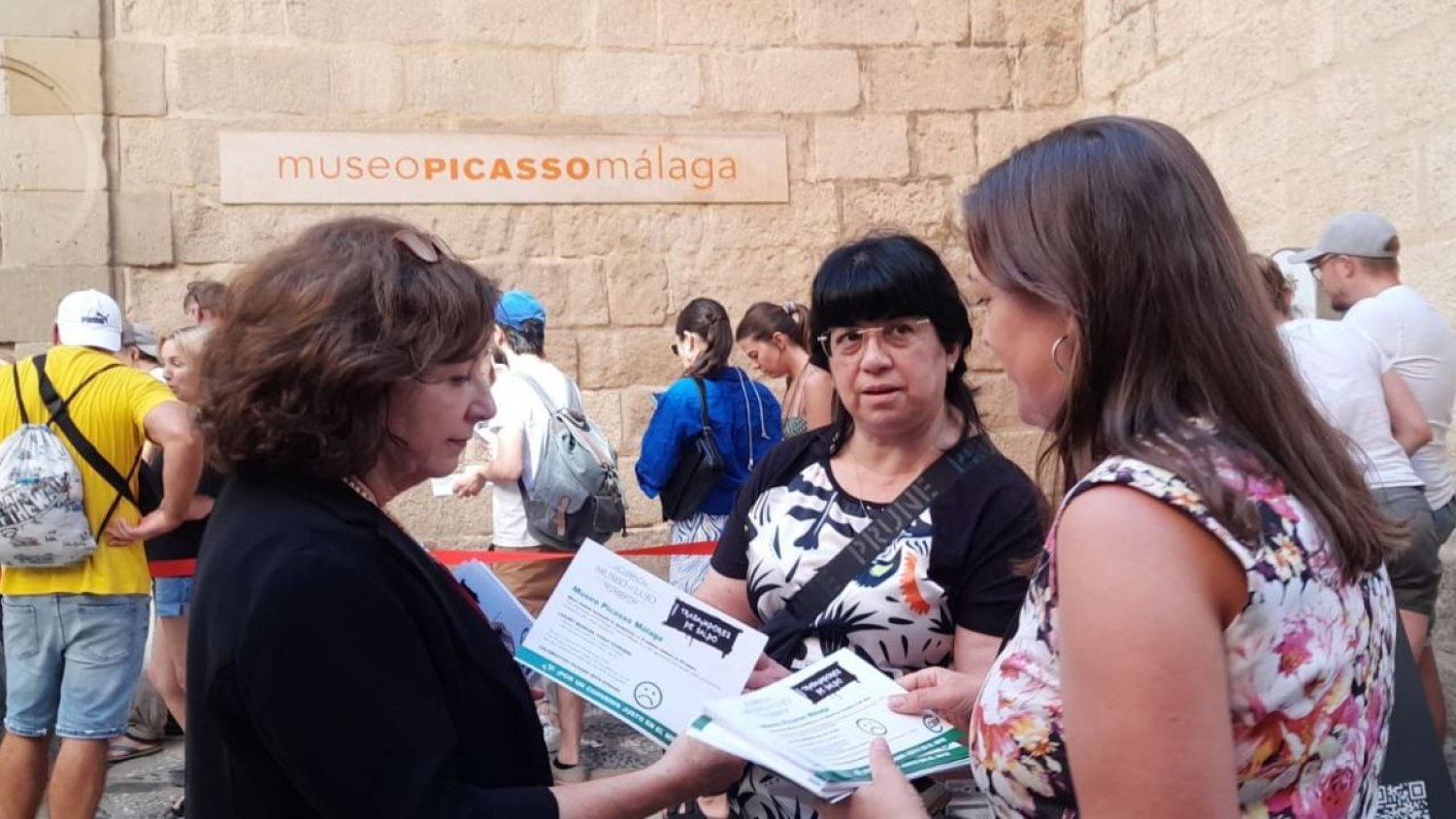 Los trabajadores del Museo Picasso Málaga reparten a los visitantes folletos sobre su conflicto laboral 